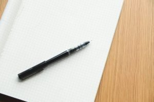 Dog CBC values chart notes in an open grid notebook with a black pen.